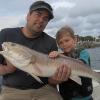 Sarasota Fishing Charters | Ben caught this 32 inch redfish fishing with Captain Brook Wallace, Bradenton, Florida. Pictured with his father, Owen admires his Dad's catch. Fish was live released. See video   www.FloridaInshoreGuide.com | Fulll Boat Charters, Bradenton, Florida | Kids fishing trips